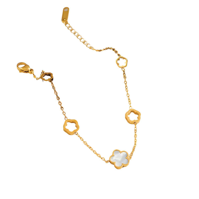 Gold bracelet with floral designs on a white surface with a black circle and rose illustration.