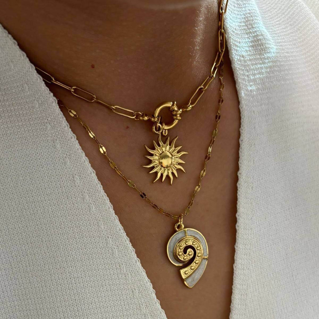 Gold Conch Shell Pendant Necklace layered with sun pendant on a delicate gold chain.