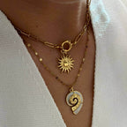 Gold Conch Shell Pendant Necklace layered with sun pendant on a delicate gold chain.