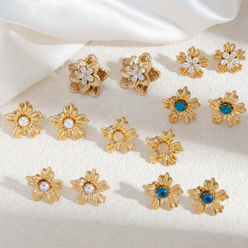 Gold Floral Stud Earrings with Turquoise Centre displayed on soft fabric background, featuring various designs with turquoise stones.