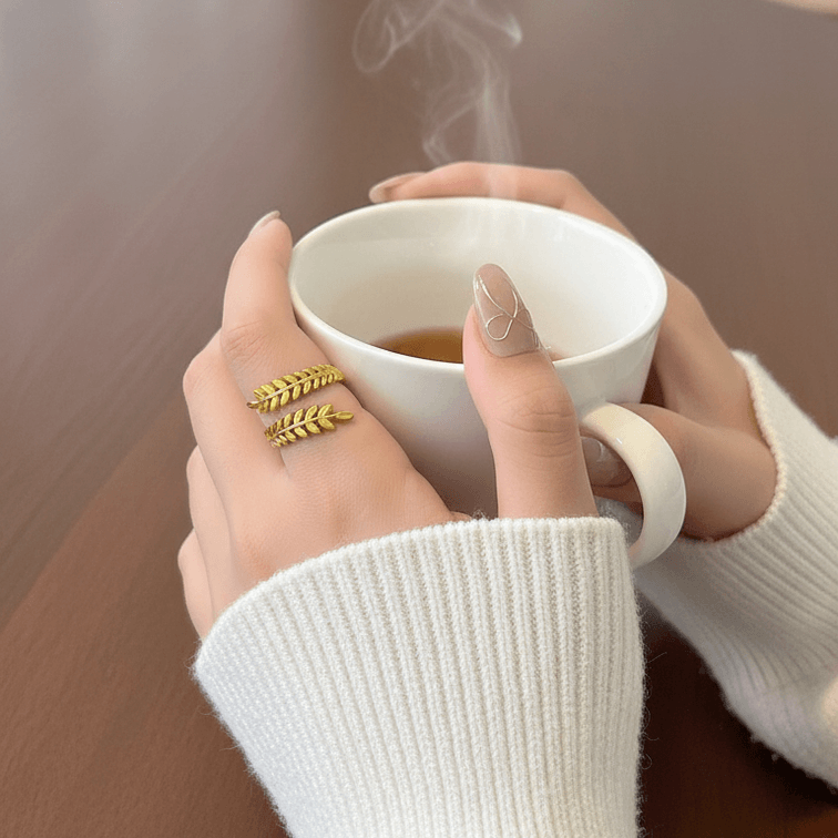 Aurelia Leaf Adjustable Gold Ring on model hand with coffe