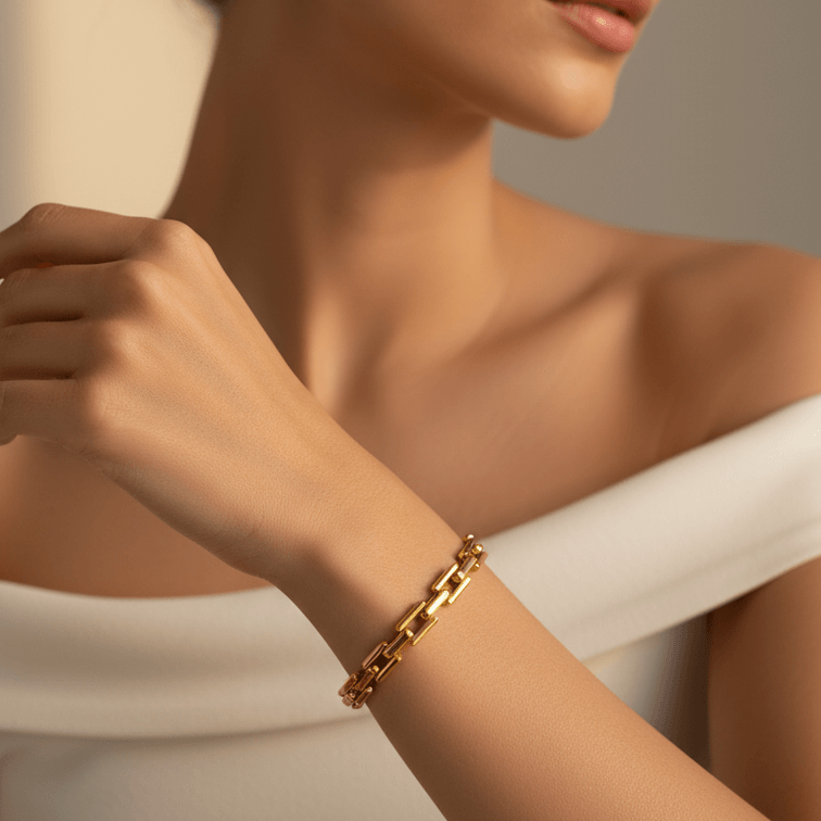 Woman wearing a gold bracelet against a neutral background