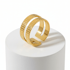 Gold Textured Double Band Ring displayed on pedestal showcasing its modern design and textured finish.