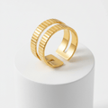 Gold Textured Double Band Ring on a display pedestal, showcasing its modern design and luminous finish.