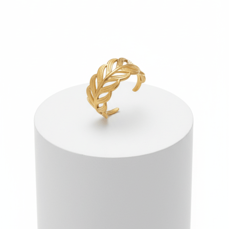 Adjustable Gold Leaf Ring displayed on a white pedestal, featuring a sculpted leaf design and an open-band silhouette.