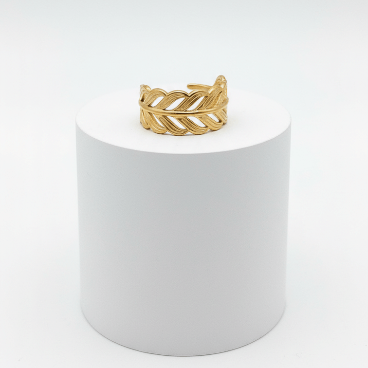 Adjustable Gold Leaf Ring displayed on a white pedestal highlighting its intricate design and adjustable open-band silhouette.