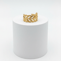 Adjustable Gold Leaf Ring displayed on a white pedestal highlighting its intricate design and adjustable open-band silhouette.