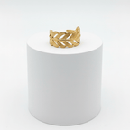 Adjustable Gold Leaf Ring displayed on a white pedestal highlighting its intricate design and adjustable open-band silhouette.
