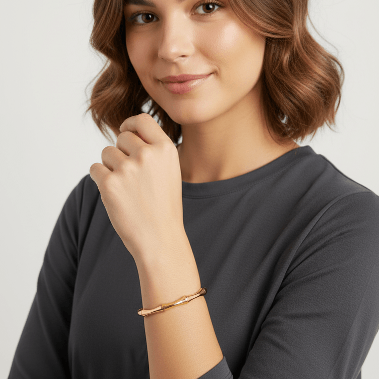 Woman showcasing a Gold Bamboo Bangle Bracelet on her wrist, highlighting its elegant and minimalist design.