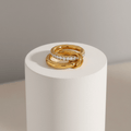 Double Layered Gold Gemstone Ring displayed on a pedestal showcasing its elegance and modern design.