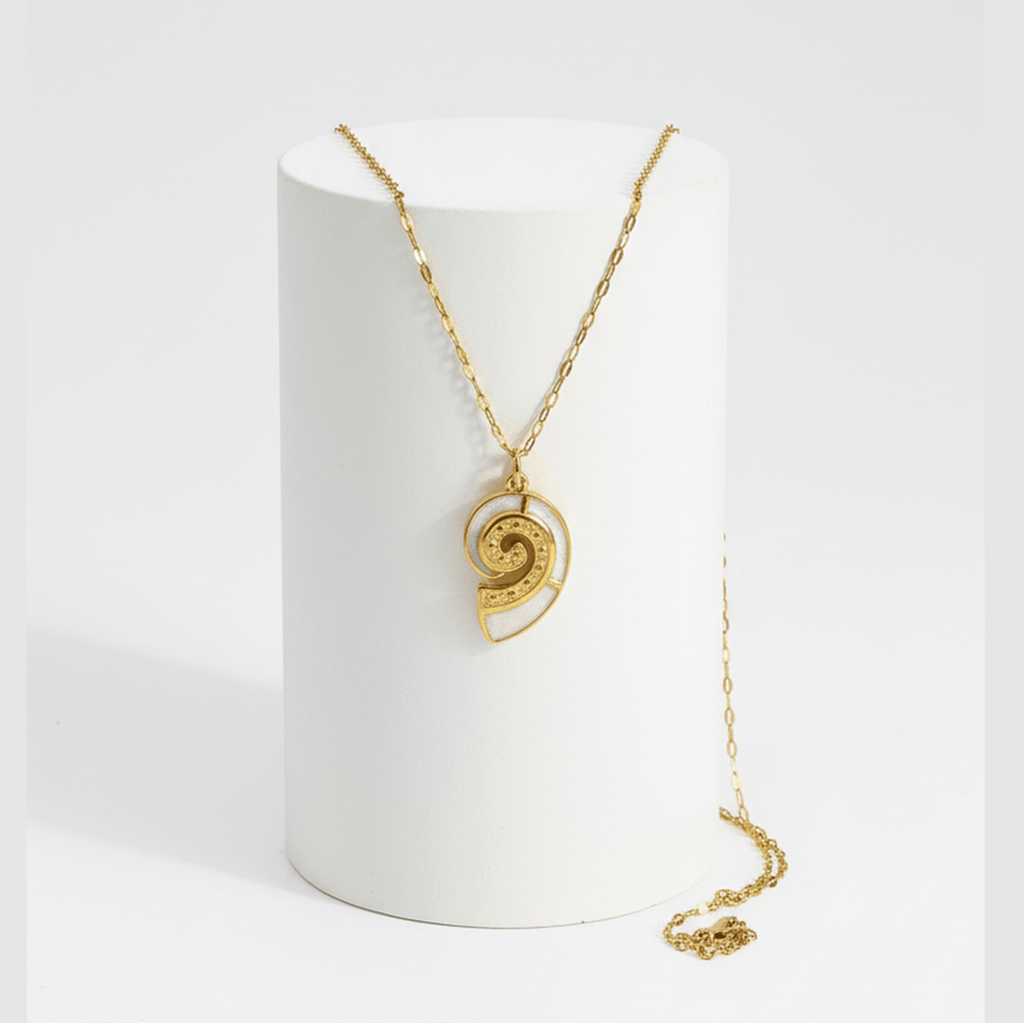Gold Conch Shell Pendant Necklace displayed on a stand, showcasing its spiral design and elegant gold finish.