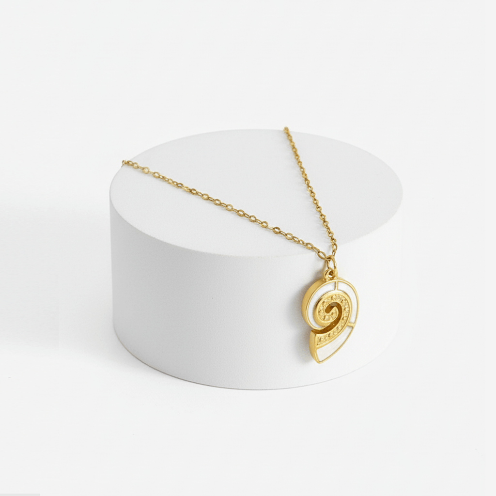 Gold Conch Shell Pendant Necklace displayed on a white pedestal, showcasing its elegant spiral design and delicate chain.