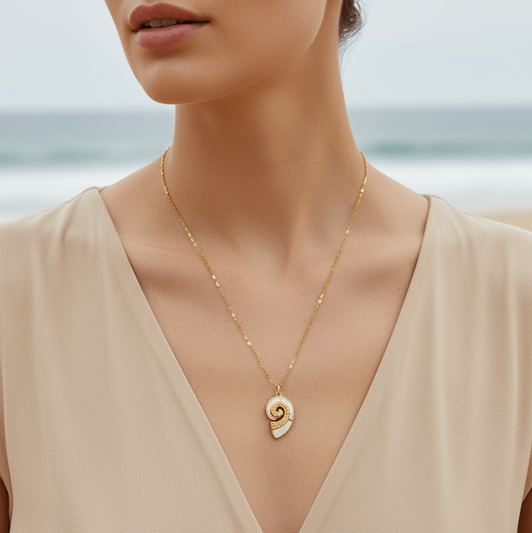 Gold Conch Shell Pendant Necklace worn by a model at the beach showcasing its coastal elegance and detailed design.