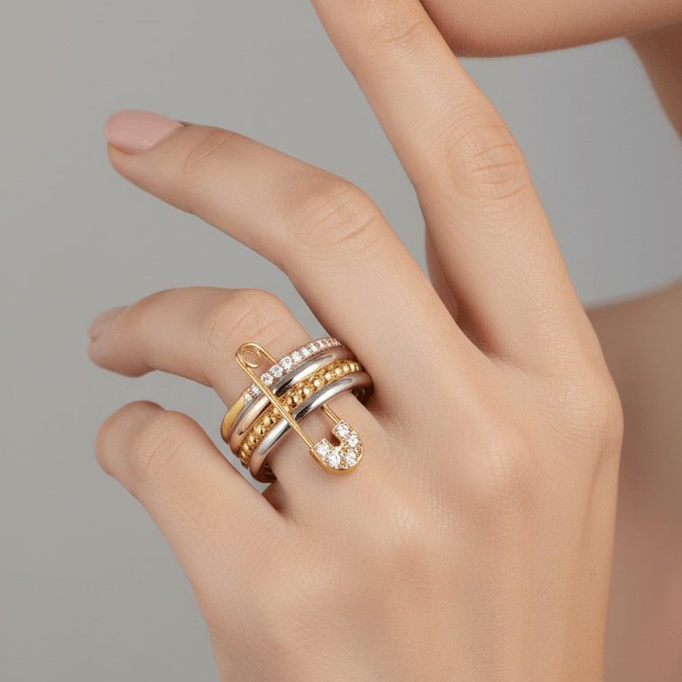 Hand wearing Layered Gold & Silver Safety Pin Ring on a neutral background