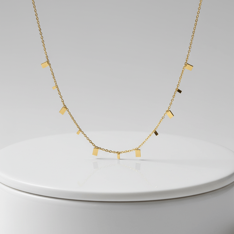 Mini Gold Bar Charm Necklace on pedestal