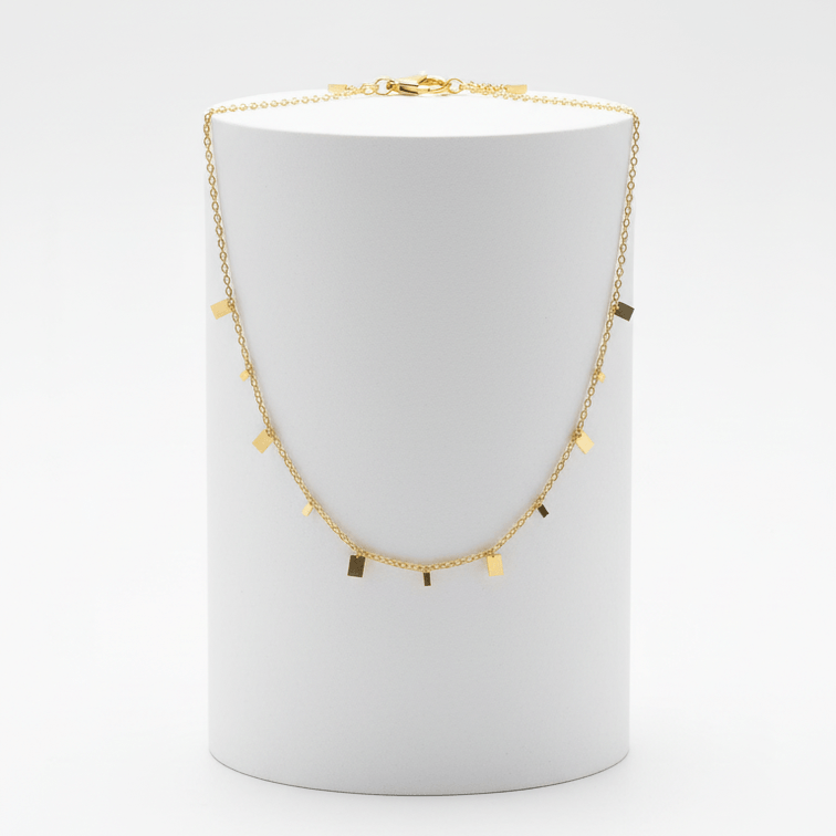 Mini Gold Bar Charm Necklace on white pedestal