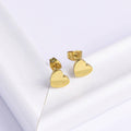 Minimal Gold Heart Stud Earrings on a light gray background