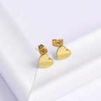 Minimal Gold Heart Stud Earrings on a light gray background