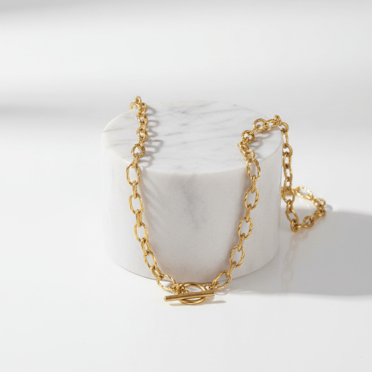 OT Clasp Chain Necklace Gold on marble pedestal 