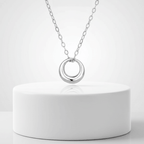 Mini Gold Circle Pendant Necklace on a sleek silver chain displaying a modern design on a minimalist background.