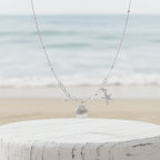 Starfish Shell Necklace Silver on pedestal beach background