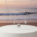 Starfish Shell Necklace Silver on pedestal beach background