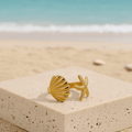 Starfish_Shell_Open_Ring_Gold_004 on a stone block with a beach background