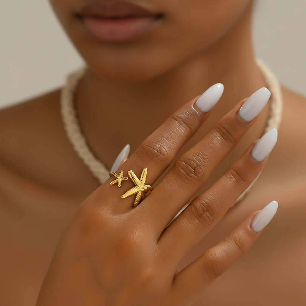 Twin Starfish Open Gold Ring on a hand with a neutral background