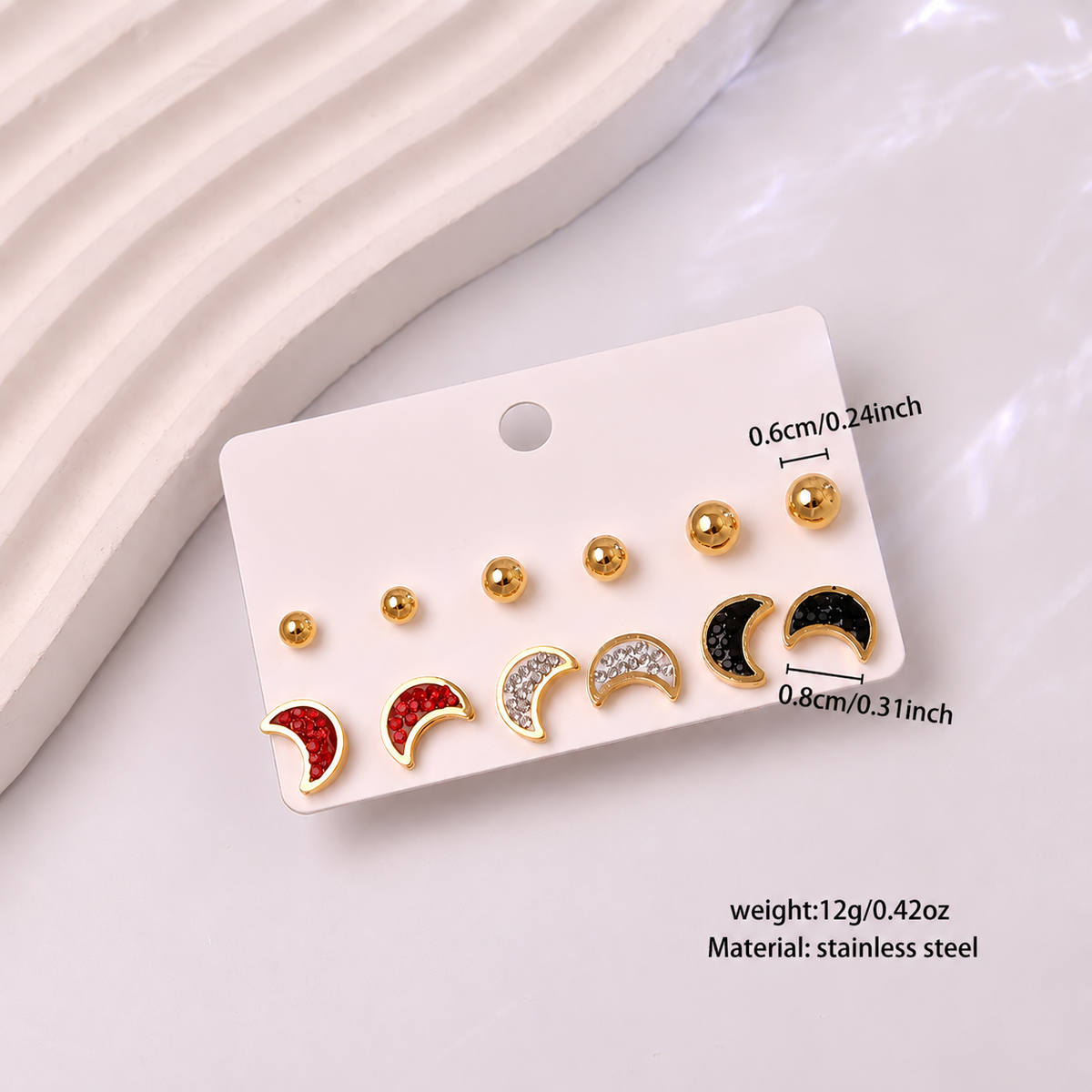 Waterproof Gold Moon Stud Earrings Set on a white card, with size and weight text annotations. The earrings include gold, silver, red, and black designs.