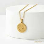 Zodiac Sign Medallion Necklace Gold  with a round pendant on a white surface, labelled 'Aquarian'.