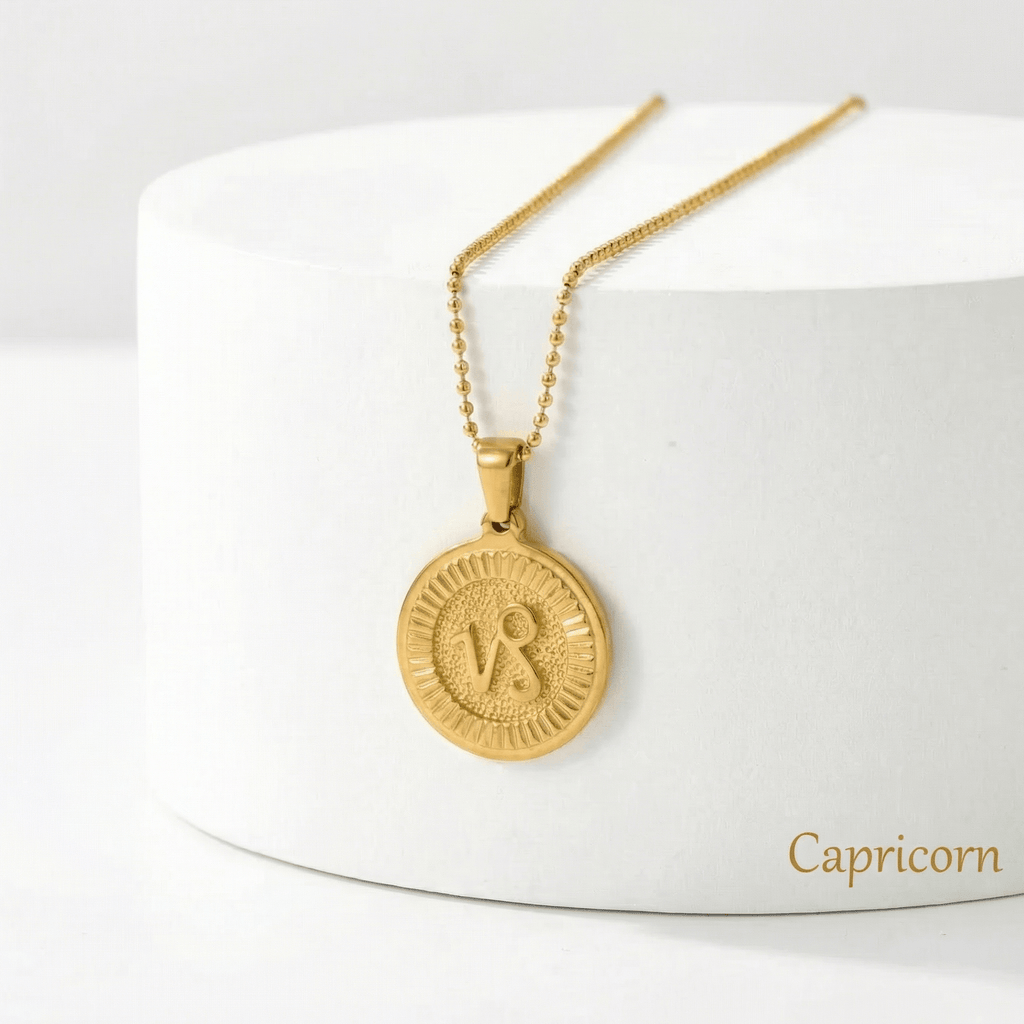 Zodiac Sign Medallion Necklace Gold with a Capricorn pendant on a white stand