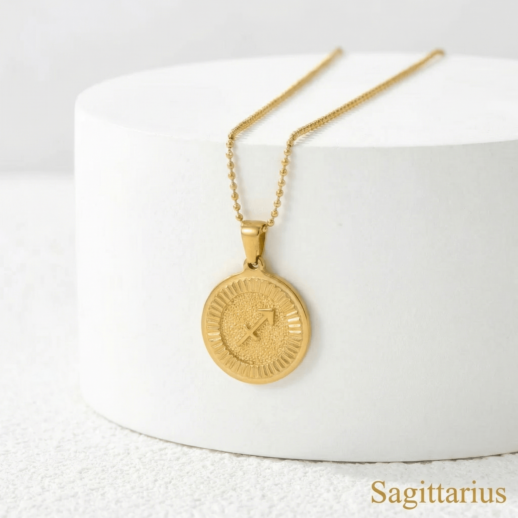 Zodiac Sign Medallion Necklace Gold with Sagittarius sign on a white surface