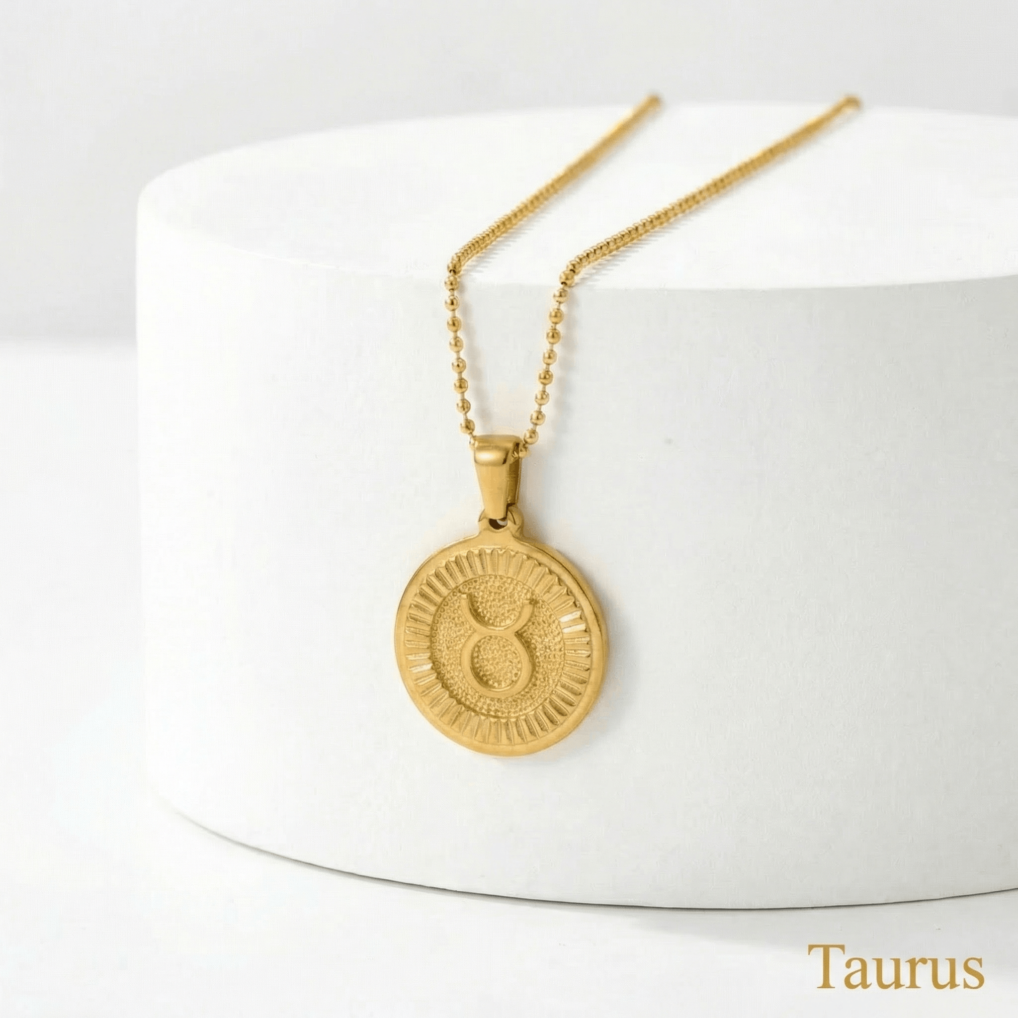 Taurus Zodiac Sign Medallion Necklace Gold on a white stand with 'Taurus' text.