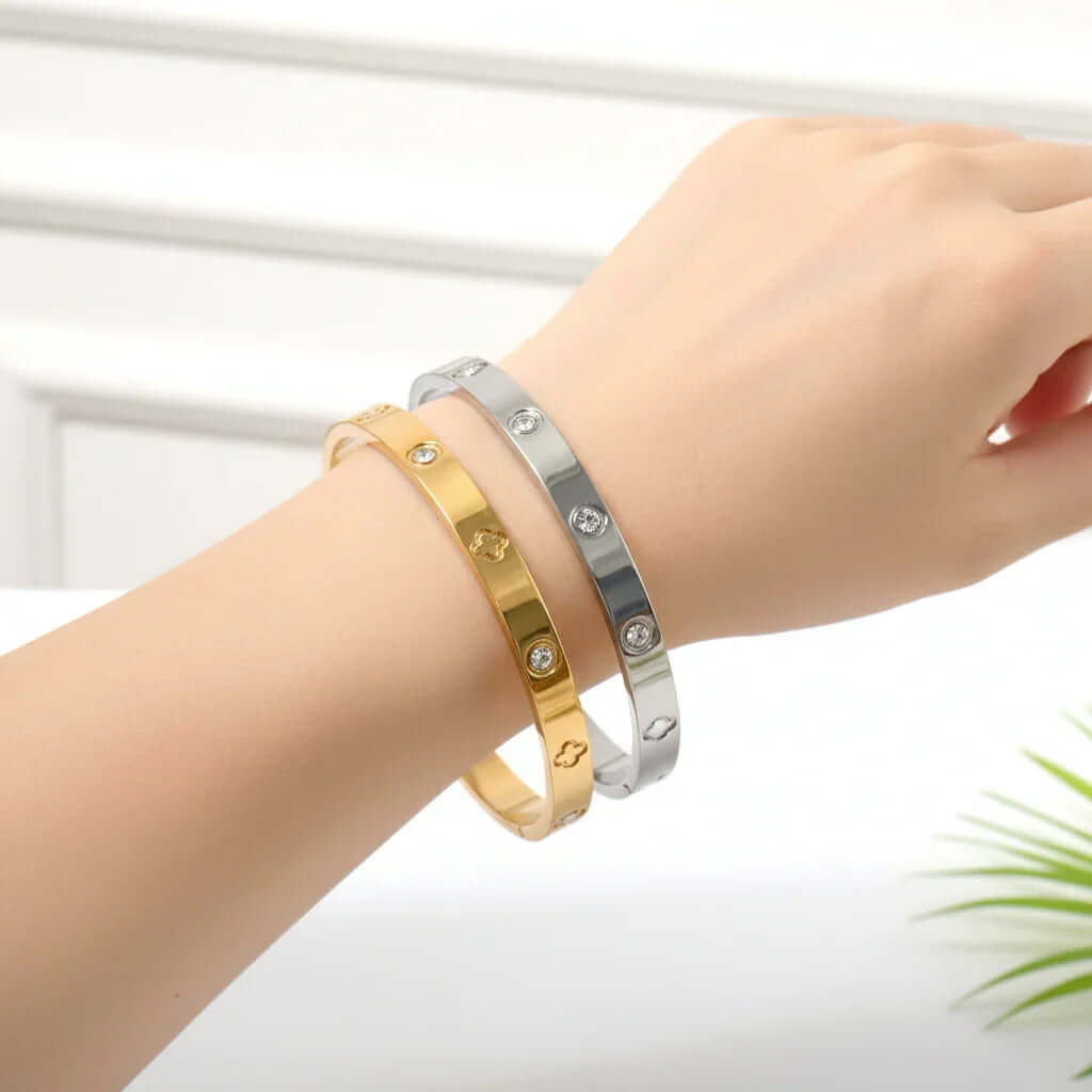 Hand wearing gold and silver Ceyrah clover engraved diamond bangle bracelet.