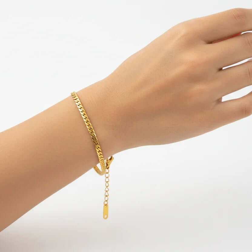 Ceyrah gold Cuban link bracelet on wrist, minimalist jewellery against white background