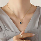 Elegant woman wearing gold blue stone pendant necklace from Ceyrah.