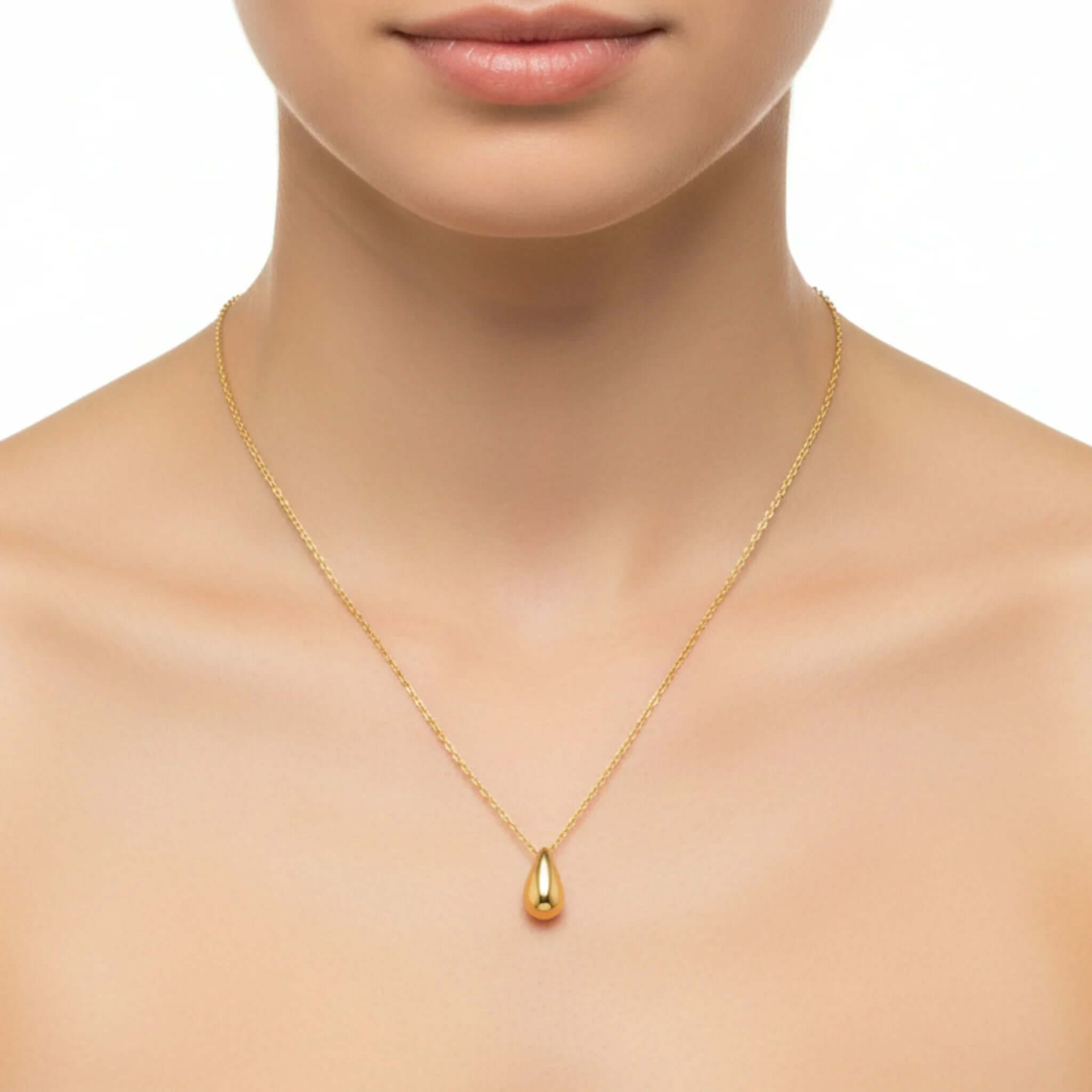 A woman wearing a Gold Water Drop Necklace featuring a delicate water drop pendant.