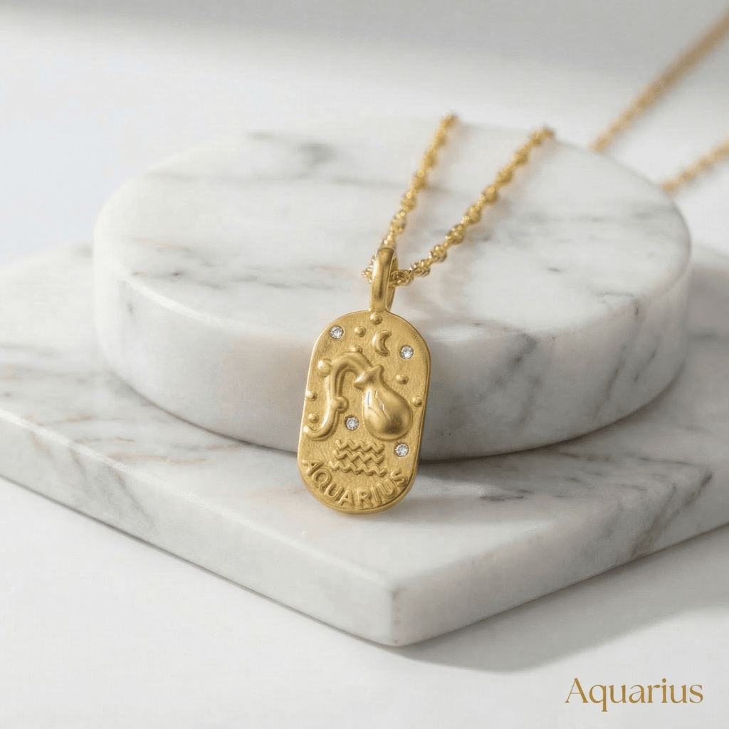Gold Engraved Zodiac Sign Necklace featuring an Aquarius pendant on a marble surface.