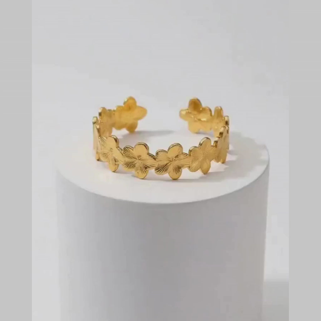 Gold Floral Cuff Bracelet on white pedestal