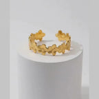 Gold Floral Cuff Bracelet on white pedestal