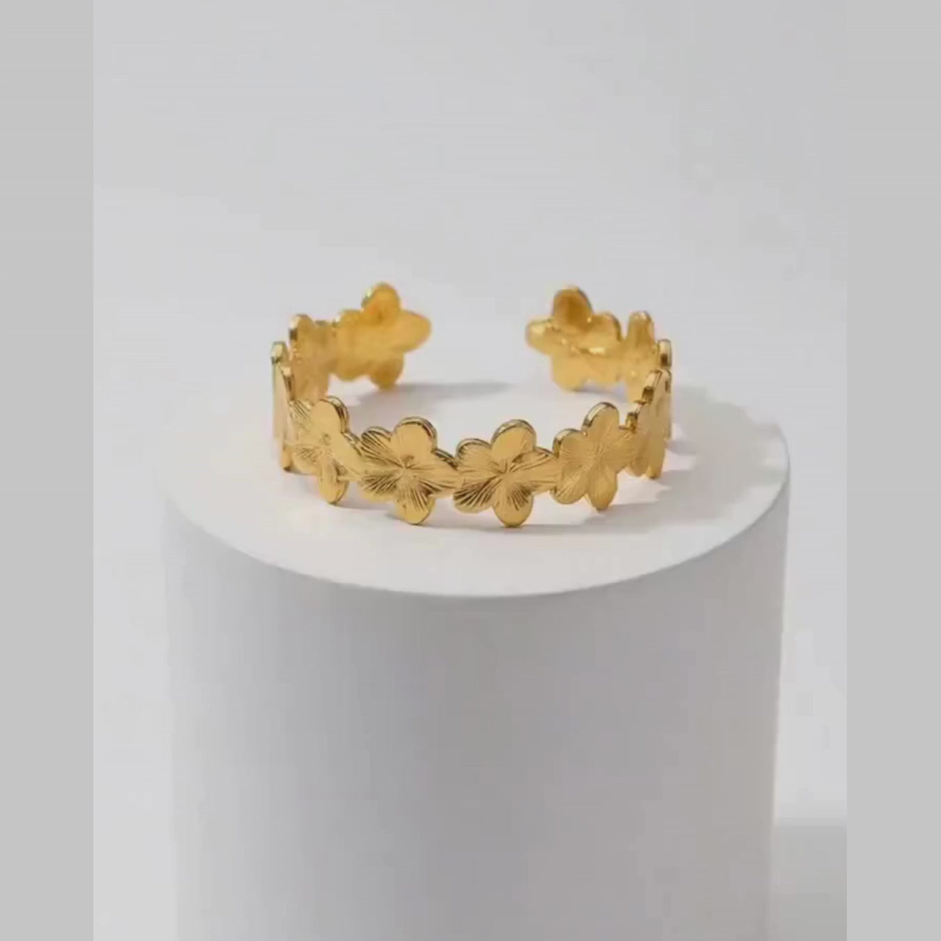 Gold Floral Cuff Bracelet on white pedestal